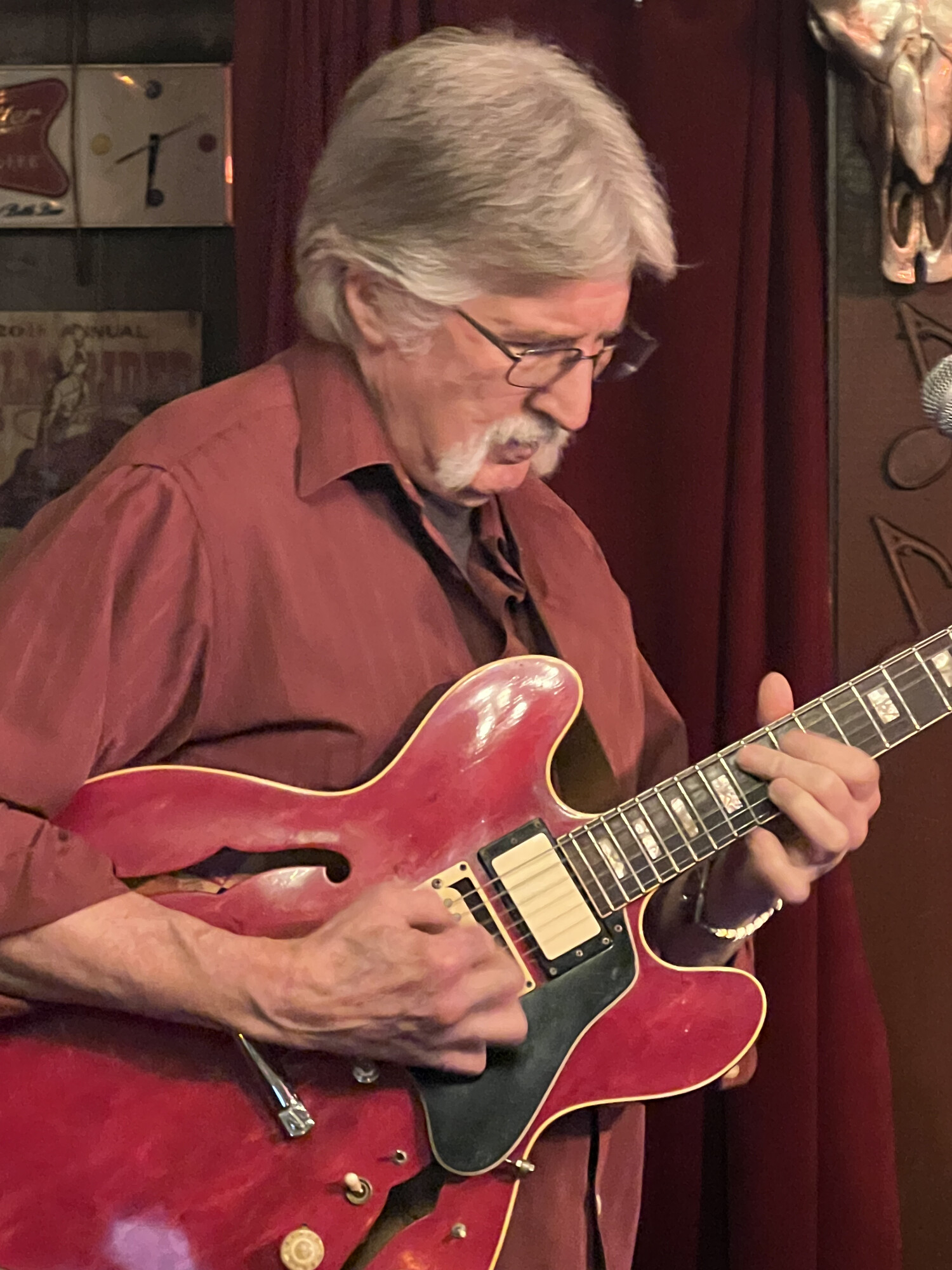 Charlie playing his red hollow-body guitar