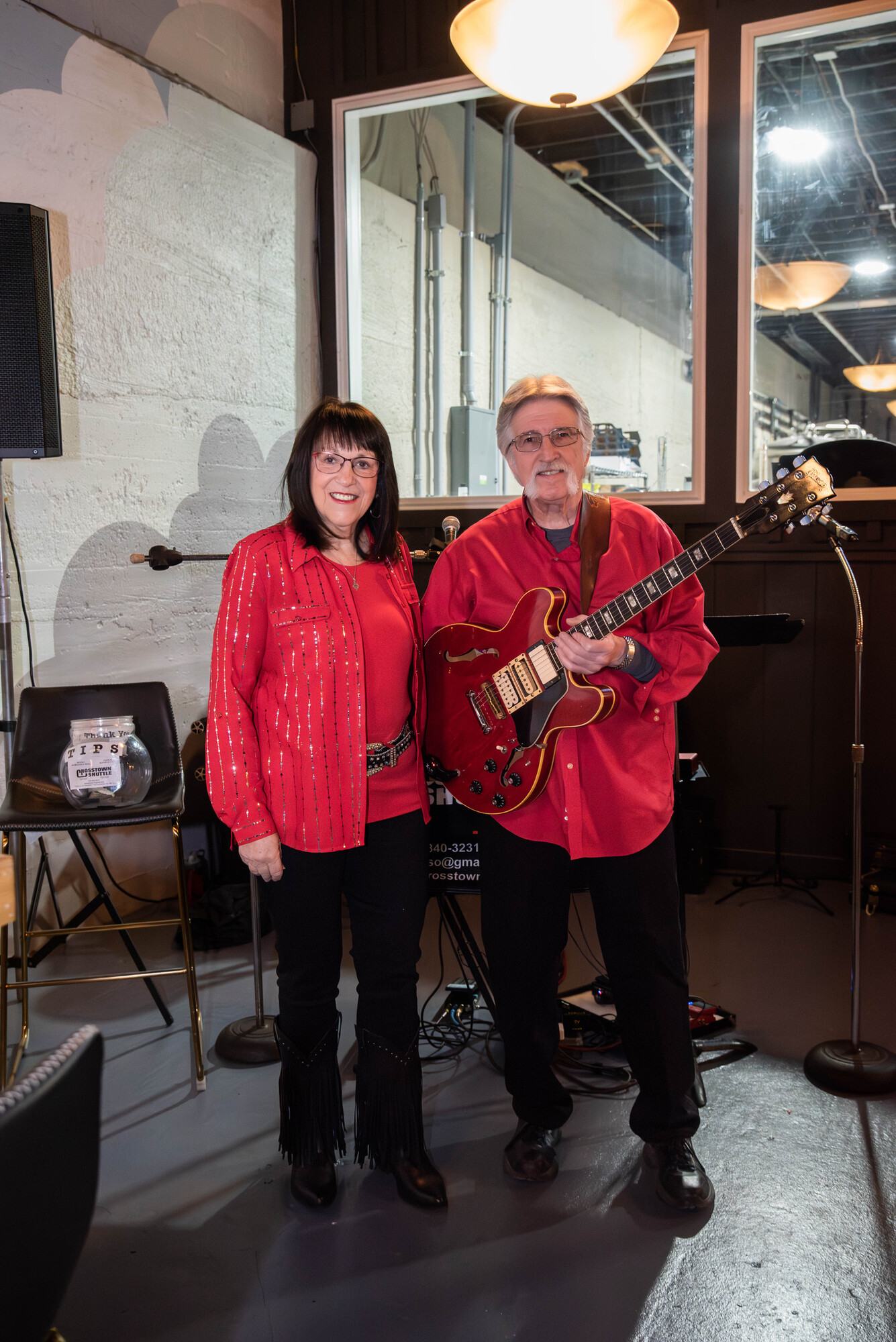 Charlie and Beverly posing in red outfits before a show